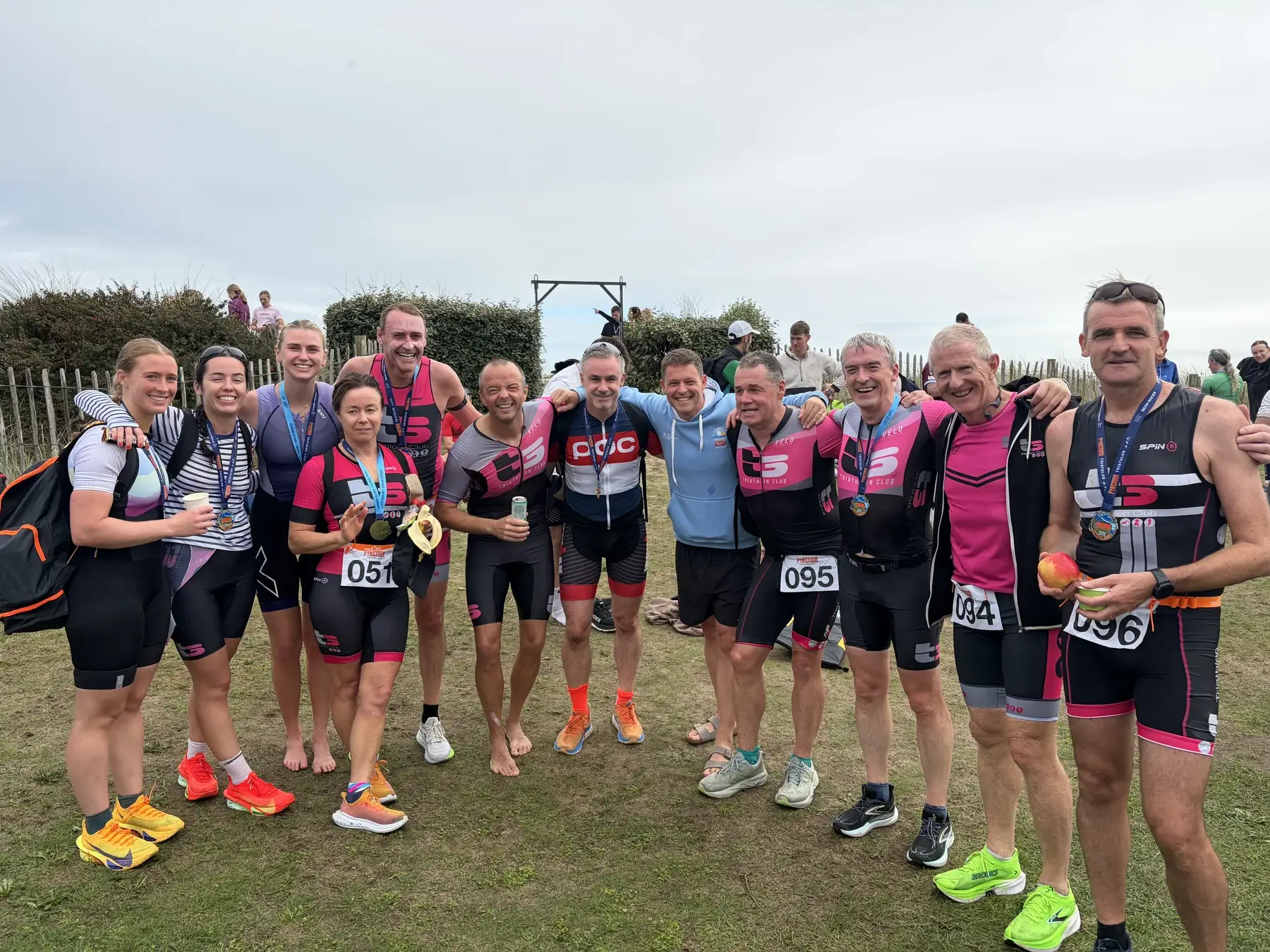 T3 members together after a race, wearing club kit and finisher medals